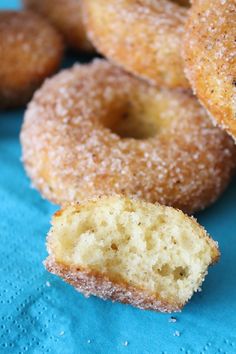 some sugared doughnuts are on a blue napkin