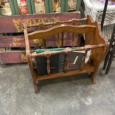 an old wooden chair with books and magazines in it next to some other items on the floor