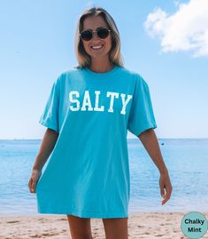 🏝️Trendy Salty Comfort Colors summer beach vacation shirt.🏝️ This Unisex t-shirt is super soft and comfortable made of 100% ring-spun ethically grown cotton. It has a relaxed fit that is made of a medium fabric that is preshrunk. Looks super cute with shirts, jeans or size up 1 to 2 sizes for an oversized beach cover up. Great gift idea for a Birthday or a beach lover! Comes in 36 pretty colors!  ☀️Please refer to the color charts in the pictures for your perfect color choice!☀️ 💠PRINT: This Blue Summer T-shirt For Surfing, Casual Ocean Color Beach Tops, Casual Ocean Color Tops For Beach, Casual Blue T-shirt For Beach Party, Summer Beachy T-shirt For Surfing, Beachy Summer Surfing T-shirt, Blue Short Sleeve Beach T-shirt, Blue Short Sleeve T-shirt For The Beach, Blue Beachy T-shirt For Vacation