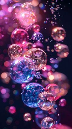 soap bubbles floating in the air on a black background with pink, blue and purple colors