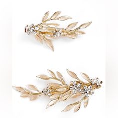 two pairs of gold tone hair clips with leaves and crystal stones on each side, set against a white background