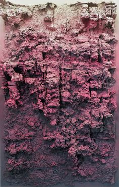 an abstract piece of art with pink paint on the wall and black ground below it