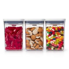 three clear containers filled with different types of candy