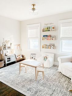 a living room filled with white furniture and lots of clutter on top of it