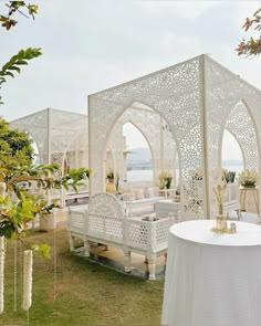 a white gazebo sitting on top of a lush green field