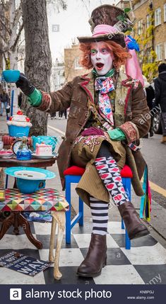 a clown sitting at a table in the street