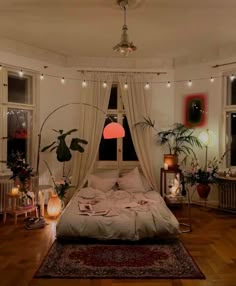 a bedroom with lots of plants and lights on the ceiling, along with an unmade bed