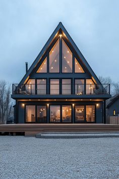 a large house with lots of windows and lights on it's roof, in the evening