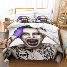 there is a bed with the face of a clown on it and two people covering their faces