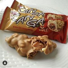 a white plate topped with two pieces of food next to a bag of chips on top of it