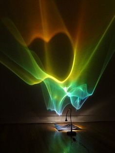 a person doing yoga in front of a colorful light