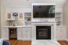 a living room filled with furniture and a flat screen tv mounted on the wall above a fireplace