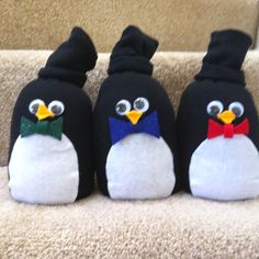 three penguin stuffed animals sitting on top of a carpeted stair case next to each other