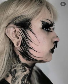 a woman with black and white makeup on her face