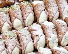 many pastries are stacked on top of each other with powdered sugar and sprinkles