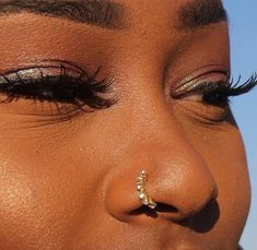 a close up of a woman's nose and nose piercing