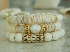 This listing is for a bone bead and shell bracelet set. There are 3 bracelets in this set that can be worn together, as a set of 2, or just one bracelet. The neutral colors easily go with anything and can be dressed up or down for a casual boho luxe vibe. Listing is for the set or just buy one bracelet. Beads are between 8 and 10mm. Bracelets measure 7 inches each. More from my spring summer collection: www.etsy.com/shop/SoCalLux?ref=seller-platform-mcnav&section_id=37561207 To view my shop clic Bohemian Gold Beaded Bracelets With Shell, White Heishi Beads Bohemian Stretch Bracelet, Bohemian Gold Beaded Shell Bracelets, Bohemian White Heishi Beads Stretch Bracelet, Bohemian Stackable Jewelry For The Beach, Bohemian Stackable Beach Jewelry, White Bohemian Shell Bracelet, Bohemian Shell Cream Jewelry, Bohemian Beach Stackable Jewelry