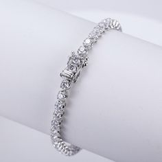 This timeless diamond tennis bracelet in 14K gold is a symbol of elegance and sophistication. Featuring a seamless row of brilliant-cut diamonds, this bracelet offers a radiant sparkle that complements any outfit. The meticulous craftsmanship is evident in each individually set diamond, designed to catch the light from every angle. A secure clasp with additional diamond accents ensures both style and safety. Whether for a special occasion or everyday luxury, this tennis bracelet is the perfect blend of classic beauty and modern grace, making it a cherished addition to any jewelry collection. Dazzling Diamond Bracelet With Accents For Anniversary, Anniversary Brilliant Cut Cubic Zirconia Tennis Bracelet, Cubic Zirconia Tennis Bracelet With Brilliant Cut For Anniversary, Anniversary Tennis Bracelet With Brilliant Cut Cubic Zirconia, Anniversary Diamond White Diamond Bracelet With Prong Setting, Dazzling Diamond Tennis Bracelet For Anniversary, Dazzling Tennis Bracelet With Diamond Accents For Anniversary, Diamond Tennis Bracelet For Anniversary, Diamond Tennis Bracelet With Prong Setting For Anniversary