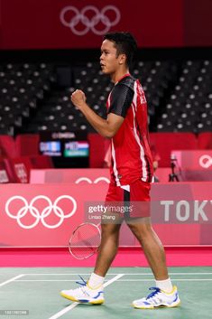 a man walking across a tennis court holding a racquet