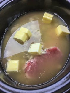 a pot filled with soup and cubes of meat