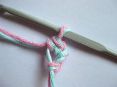 the crochet hook is being used to make a knot