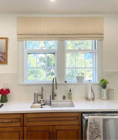 a kitchen with white counter tops and wooden cabinetry next to a dishwasher