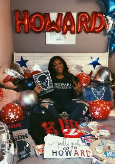 a woman sitting on top of a bed surrounded by balloons