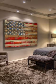 a bedroom with a large american flag painting on the wall next to a bed and chair