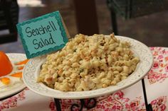 there is a bowl of food on the table with a sign that says seafood salad