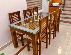 there is a glass table and chairs in the dining room with stairs leading up to the second floor