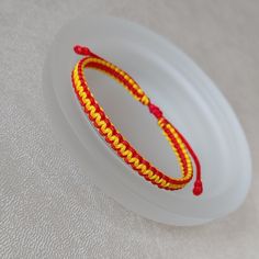 two red and yellow bracelets sitting on top of a white frisbee