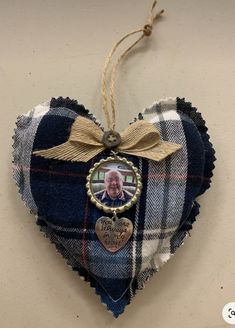 a heart shaped ornament with a photo hanging from it's side on a wall