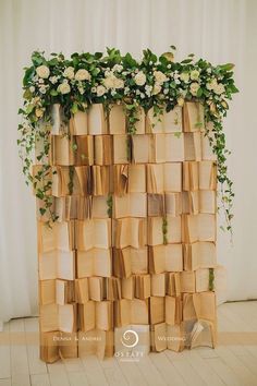 an arrangement of books stacked on top of each other with flowers growing out of them