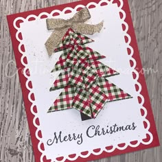 a card with a christmas tree made out of paper on top of a wooden table