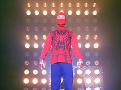 a man in a red spider suit on stage with lights behind him and the caption says, this is his best suit