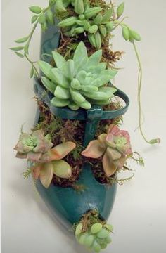 a blue vase filled with lots of green plants