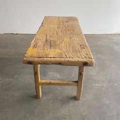 a wooden bench sitting on top of a cement floor