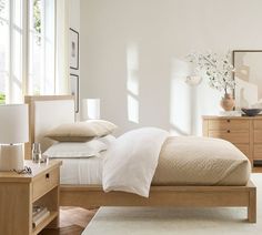 a bedroom with white walls and wooden furniture