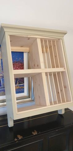 a wooden shelf sitting on top of a black dresser