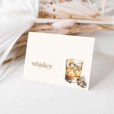 a card with an image of a glass of whiskey and ice cubes on it