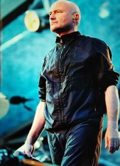 a man standing on stage with his hands in his pockets and looking off to the side