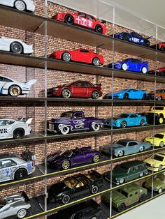 a display case filled with lots of different types of toy cars on top of shelves