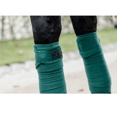 the legs of a person wearing green socks and riding boots with black pants on them