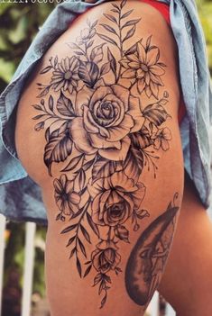 a woman's thigh with flowers and leaves on it