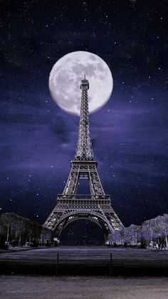 the eiffel tower lit up at night in paris, france with the full moon behind it