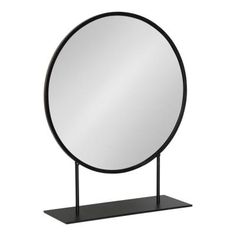 a round mirror sitting on top of a metal stand