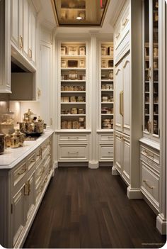 a kitchen filled with lots of white cupboards and counter top space next to a wooden floor