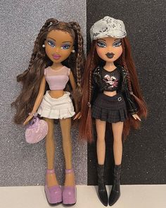 two dolls are standing next to each other