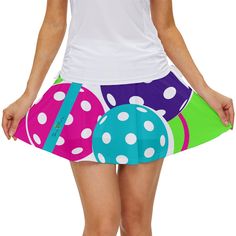 a woman wearing a colorful skirt with polka dots on the bottom and an egg in the middle