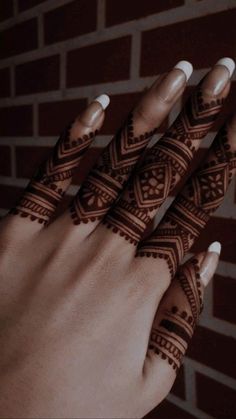 a woman's hand with henna tattoos on it